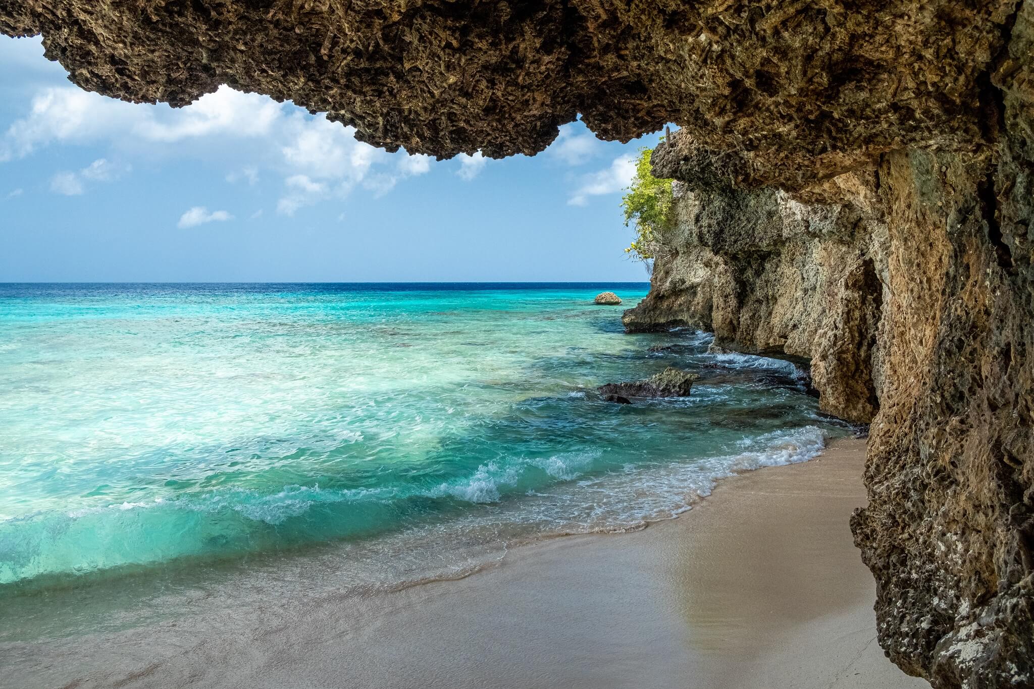 Curaçao: overhangende rots bij de zee
