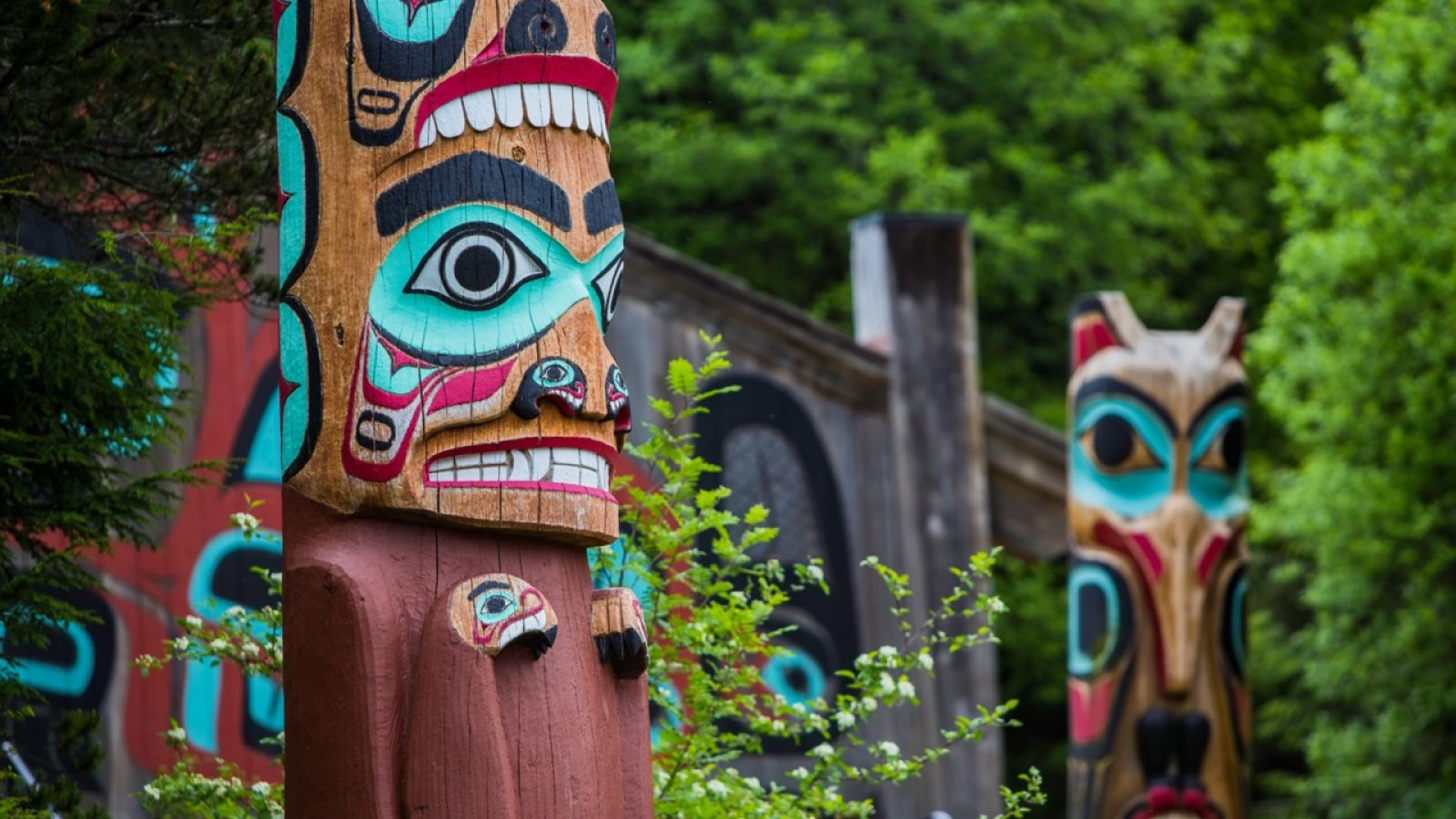 Detail of totem pole at Saxman Village tribal house near Ketchikan Alaska with Sun Raven in background; Shutterstock ID 438946603